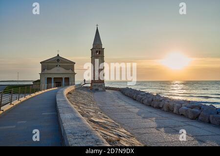 Caorle, Venedig, Italien, Sept 19 2020: Die Kirche der Madonna des Engels in Caorle bei Sonnenaufgang am Ende des Sommers von den westlichen Felsen Stockfoto