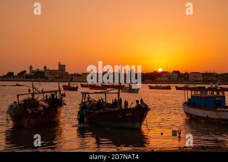 Mandvi ,23, August , 2019 : Fischerboote auf arabischem Meer am Abend mit Sonnenuntergang im Hintergrund von Mandvi Stadt, Kutch, Gujarat, Indien, Asien Stockfoto