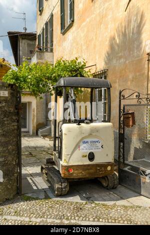 LENNO, COMER SEE, ITALIEN - JUNI 2019: Minibagger in der engen Eingang zu einem Haus für Renovierungsarbeiten in Lenno am Comer See geparkt. Stockfoto