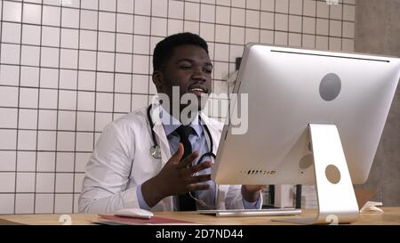 Afrikanische männlicher Arzt in Video Konferenz auf seinem Computer. Stockfoto