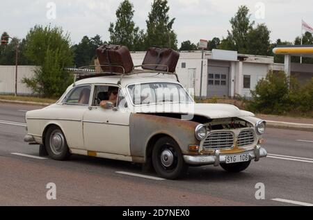 Eine Reise in einem alten VOLVO Auto mit Koffern, eine lustige Szene. Stockfoto