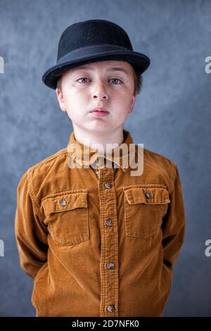 Schöner multi-rassischen asiatischen kaukasischen kleinen Jugendlichen Delinquent Jungen trägt Gold Rostfarbenes Hemd aus Cord mit Knopfleiste und schwarzem Schweinebraten fedora Hut Stockfoto