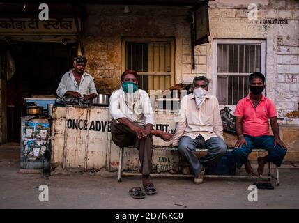 Jaisalmer, Rajasthan / Indien - september 24 2020 : Gruppe von Männern mittleren Alters sitzen und warten an einem lokalen Tee-Stand am Morgen für Chai / Tee zu ar Stockfoto