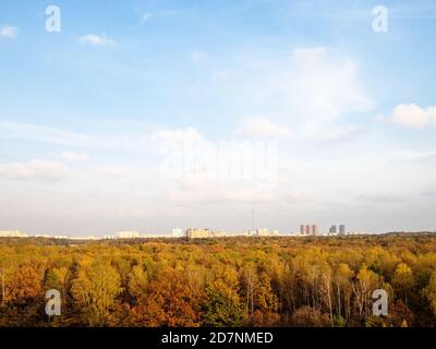 Blauer Himmel mit weißen Wolken über der Stadt und bunten Wald Am Herbstnachmittag Stockfoto