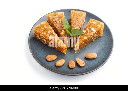 Traditionelle türkische Süßwaren-Czerye aus karamellisierter Melone, gerösteten Walnüssen, Haselnüssen, Pistazien in blauer Keramikplatte isoliert auf weißem Backgrou Stockfoto