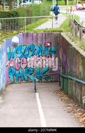 Willkommen im Central Park Graffiti-Stil Street Art auf der Unterführung, die zum Park in Chelmsford, Essex, Großbritannien führt. Unterirdischer Zugang zum städtischen Grünraum Stockfoto