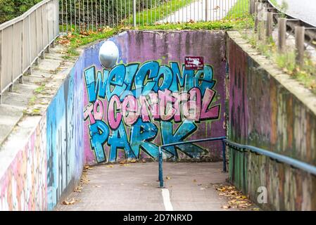 Willkommen im Central Park Graffiti-Stil Street Art auf der Unterführung, die zum Park in Chelmsford, Essex, Großbritannien führt. Unterirdischer Zugang zum städtischen Grünraum Stockfoto