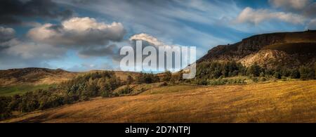 Panorama, Pennine Hügel und Bäume in Dovestone, Saddleworth, Greater Manchester, mit goldenen Gräsern, Wolken und blauen Himmel, an einem Juliabend Stockfoto