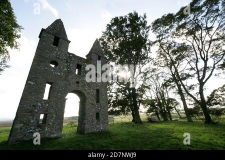 Grenzt an den Hunty Mundy im Mellerstain House bei Kelso. Hundy Mundy Tower, Tower in Melrose, Schottland, Großbritannien. Eine Torheit, die nach einer Prinzessin benannt wurde, die Körper in einer natürlichen Waldbestattung überblickt.Eine gotische Torheit, die zur Vervollständigung der entworfenen aussicht, die sich südöstlich von Mellerstain in den schottischen Grenzen erstreckt, gebaut wurde, befindet sich Hundy Mundy in einer spektakulären Lage, eine Meile (1,5 km) nordöstlich von Smailholm und 5 Meilen (8 km) Nordwestlich von Kelso. Es wurde 1726 begonnen und besteht aus einem hohen Torbogen zwischen quadratischen Türmen, die von Pyramiden bedeckt sind, und war das Werk von William Adam (1689 - 1748), der der Architekt gewesen war Stockfoto