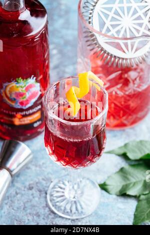 Roter alkoholischer Cocktail mit verschiedenen Barkeeper's Utensilien Stockfoto