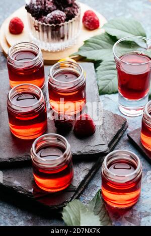 Rote alkoholische Schüsse mit verschiedenen Barkeeper's Utensilien Stockfoto