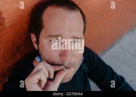 Mann, der auf der Straße eine Zigarette raucht Stockfoto