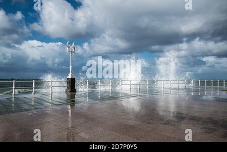 Wellen krachen an der Promenade in Gijon, Nordspanien. Raues Meer an der Küste von Gijon, Asturien, Spanien. Stockfoto