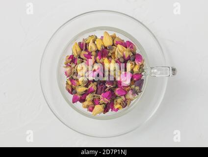 Rose Knospen mischen Tee in Klarglas Tasse auf weißem Hintergrund. Draufsicht Stockfoto