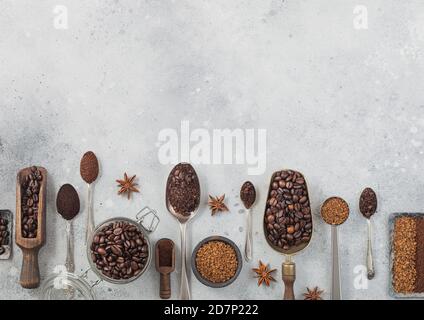 Gefriergetrocknetes Instant-Kaffee-Granulat mit gemahlenem Kaffee und Bohnen in verschiedenen Löffeln und Kugeln auf schwarzem Hintergrund mit Glasglas und Stahlplatten. Sp Stockfoto