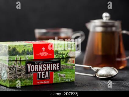 LONDON, UK - 21. OKTOBER 2020: Pack von Yorkshire schwarzen Tee mit Teekanne und vintage Sieb Infuser auf schwarzem Hintergrund.. Produkt von Taylors von Harrog Stockfoto