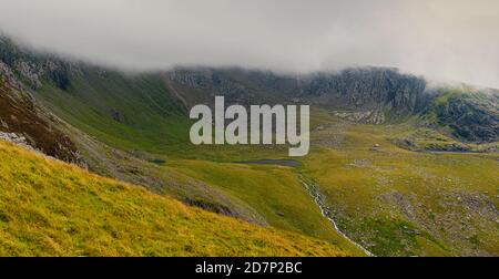 Panoramablick auf Yr Wyddfa - Snowdon am bewölkten Tag vom Ranger Path. Höchste Bergkette in Wales bedeckt von Wolken. Snowdonia Nationalpark. VEREINIGTES KÖNIGREICH. Stockfoto