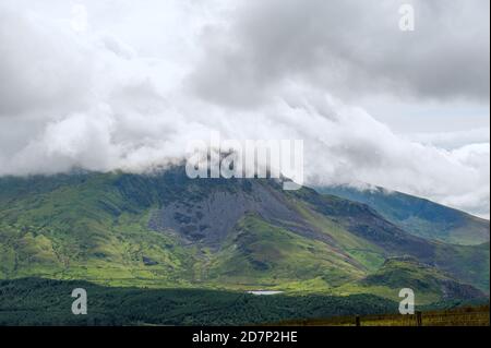 Panoramablick auf Yr Wyddfa - Snowdon am bewölkten Tag vom Ranger Path. Höchste Bergkette in Wales bedeckt von Wolken. Snowdonia Nationalpark. VEREINIGTES KÖNIGREICH. Stockfoto