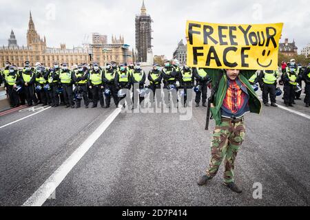 London, Großbritannien. Okt. 2020. Ein Mann mit Plakat hält an der Westminster Bridge. Die Bewegung Unite for Freedom organisierte einen Protest unter dem Banner "Wir haben die Macht", um den Kräften zu zeigen, dass sie sich nicht mit dem einverstanden erklären, was sie als ungesetzliche Sperre ansehen. Kredit: Andy Barton/Alamy Live Nachrichten Stockfoto