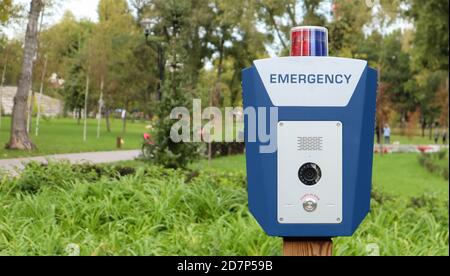 Nottaster in einem öffentlichen Stadtpark mit einem englischen Wort Notfall. SOS, Polizei, Panik. Sicherheitskonzept für Personen. Notruf um Hilfe Stockfoto