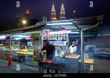 Kuala Lumpur, Malaysia. Okt. 2020. Ein Verkäufer trägt Maske bereitet Essen in Kuala Lumpur, Malaysia, 24. Oktober 2020. Malaysia meldete 1,228 neue COVID-19-Infektionen mit der höchsten täglichen Spitze seit dem Ausbruch, sagte das Gesundheitsministerium am Samstag und brachte die nationale Summe auf 25,742. Quelle: Chong Voon Chung/Xinhua/Alamy Live News Stockfoto