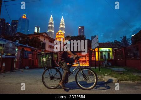 Kuala Lumpur, Malaysia. Okt. 2020. Ein Mann mit Maske fährt mit dem Fahrrad in Kuala Lumpur, Malaysia, 24. Oktober 2020. Malaysia meldete 1,228 neue COVID-19-Infektionen mit der höchsten täglichen Spitze seit dem Ausbruch, sagte das Gesundheitsministerium am Samstag und brachte die nationale Summe auf 25,742. Quelle: Chong Voon Chung/Xinhua/Alamy Live News Stockfoto