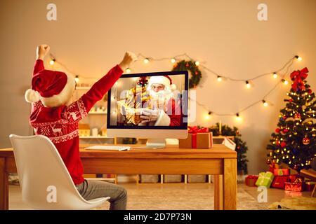 Überglücklich kleiner Junge, der Werbespots für das neue Jahr ansieht oder Video hat Rufen Sie mit dem Weihnachtsmann Stockfoto