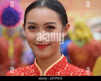 Kostümierte hübsche thailändische Teilnehmerin und Tänzerin bei Bangkoks Chinese New Year Street Parade posiert für die Kamera. Stockfoto