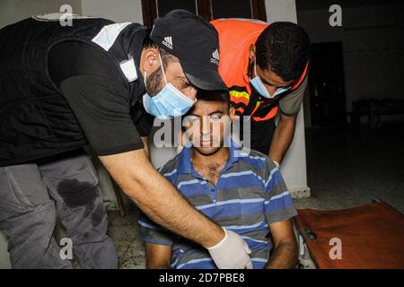 24. Oktober 2020: Gaza, Palästina. 24. Oktober 2020. Eine Krankenwagen-Crew nimmt an einer Person Teil, die nach einer Verletzung in Bir el Naja im nördlichen Gaza-Streifen von Beschlagnahmen betroffen ist. Der Patient wurde zuerst vor Ort behandelt, bevor er in das indonesische Krankenhaus in Jabalia im nördlichen Gazastreifen überführt wurde.Quelle: Ahmad Hasaballah/IMAGESLIVE/ZUMA Wire/Alamy Live News Stockfoto