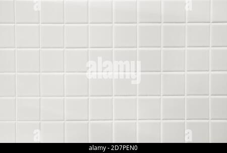 Weiße Keramik-Quadrate mit weißem Füllstoff an der Badezimmerwand. Hintergrund. Stockfoto