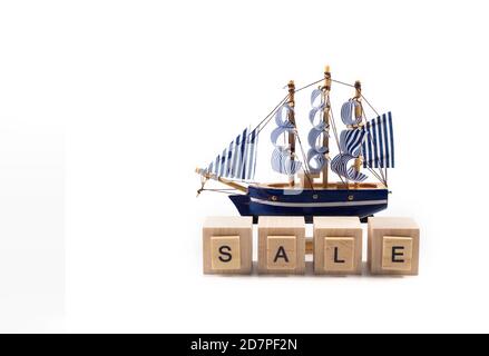 Ferien Touren Verkauf Konzept - kleine Spielzeugboot und Inschrift VERKAUF. Stockfoto