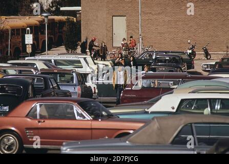 Woodward High School in Bethesda; Maryland. Viele Schüler fahren mit ihren eigenen Autos zur Schule. Schulbusse im Hintergrund ca. 1973 Stockfoto