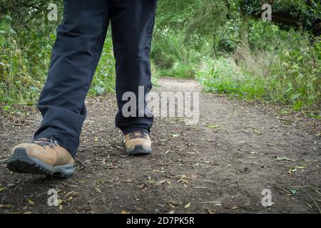 Frau trägt Wanderschuhe Wandern auf einem Wanderweg in Großbritannien Auf dem Land Stockfoto
