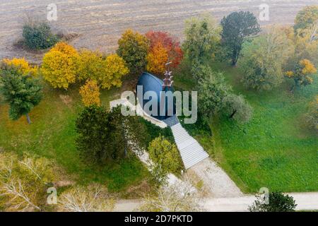 Drohnenfoto einer Kapelle am Gebart See an einem Herbstmorgen in der Stadt Zalaegerszeg, Ungarn Stockfoto