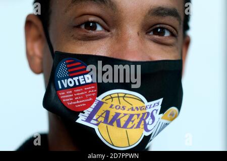 Los Angeles, Kalifornien, USA. Okt. 2020. Ein Wähler trägt einen Sticker "Ich habe gestimmt" auf seiner Lakers Gesichtsmaske, nachdem er am Samstag, den 24. Oktober 2020, in einem Wahlzentrum im Staples Center in Los Angeles seine Stimme abgegeben hat. Kredit: Ringo Chiu/ZUMA Wire/Alamy Live Nachrichten Stockfoto