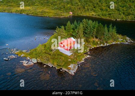 Rote Holzhütte auf einer kleinen Insel in einem See, Vestvavoy, Nordland, Lofoten, Norwegen Stockfoto