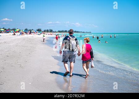 Sanibel Island, USA - 29. April 2018: Bowman's Beach mit Pärchen auf Sand und vielen Menschen im Hintergrund durch buntes Wasser Stockfoto