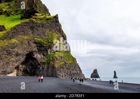 Myrdal, Island - 14. Juni 2018: Reynisfjara schwarzer Sandstrand mit vulkanischen Basaltfelsen und vielen Menschen Touristen Blick auf die Landschaft Stockfoto