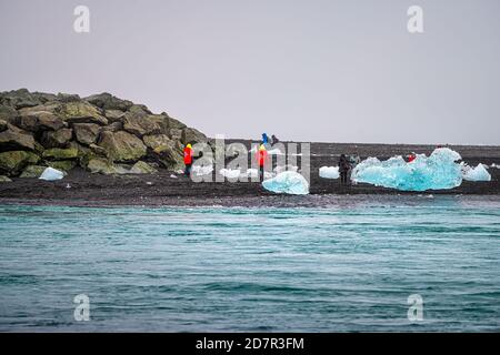 Jokulsarlon, Island - 15. Juni 2018: Gletscherlagune See Fluss Diamant Strand mit vielen Eisbergen schwimmt auf dem Wasser mit Menschen Touristen Stockfoto