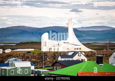 Stykkisholmur, Island - 17. Juni 2018: Moderne weiße Kirche von Architekt Jon Haraldsson auf Snaefellsnes Halbinsel in Vesturland, Island mit bunten Stockfoto