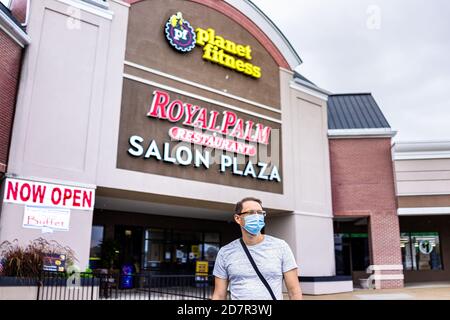 Sterling, USA - 9. September 2020: Geschäfte am Strip Mall plaza mit Menschen Mann Person in Maske von Planet Fitness-Zeichen und jetzt geöffnet während Coronavirus in Stockfoto