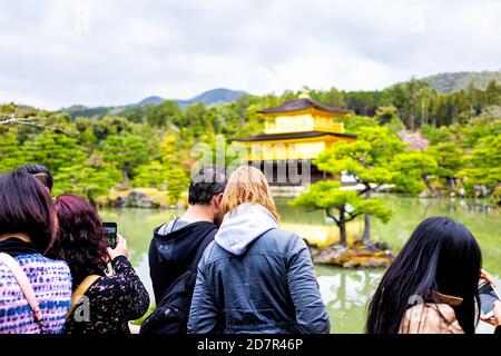 Kyoto, Japan - 10. April 2019: Kinkakuji Golden Pavilion Tempel Gebäude Rokuonji Zen buddhistischer Schrein mit vielen Menschen Touristen Paar Blick auf Sicht Stockfoto