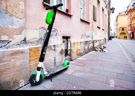 Warschau, Polen - 21. Dezember 2019: Limette Elektroroller Vermietung draußen auf der Straße im Freien auf der Straße Bürgersteig in der Altstadt Marktplatz geparkt Stockfoto