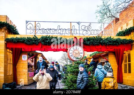 Warschau, Polen - 21. Dezember 2019: Altstadt Warszawa mit Weihnachtsmarkt in der Nähe von königlichen Schloss Platz Menschen zu Fuß durch den Eingang mit Uhr und Happy H Stockfoto