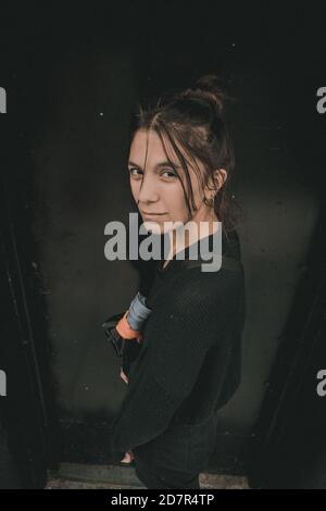 Vertikales Hochwinkelporträt einer lässigen unglücklichen Frau, die posiert In einer Straße und Blick auf die Kamera Stockfoto