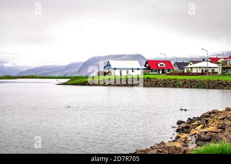 Landschaftsansicht des kleinen Dorfes am Fjord Wasserfluss und Berge im kleinen Fischerort Hofn in Island Stockfoto