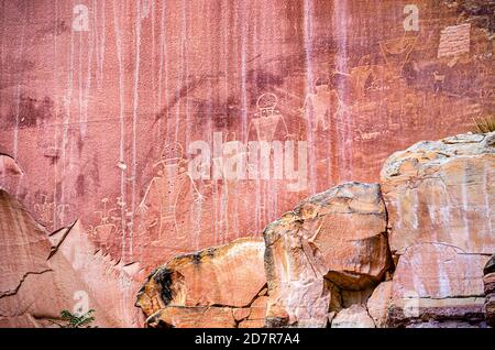 Felswand Petroglyphen Symbole der alten Anasazi Indianer Stamm Menschen Im Capitol Reef National Park in Utah mit rotem Felsen Farbe Nahaufnahme Stockfoto