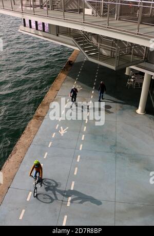 Radfahrer fahren entlang der Paseo Maritimo de Santander Kantabrien Spanien An einem sonnigen Oktobermorgen im Schatten der Centro Botin Kunstzentrum Stockfoto