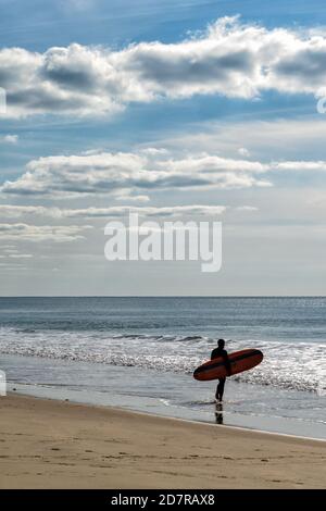 Ein männlicher Surfer geht in den Atlantik auf der Französische Cote d'Argent, um einige Wellen zu fangen Stockfoto