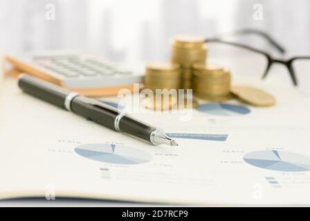 Stift auf Finanzbericht mit Rechner, Geld auf dem Tisch des Finanzberaters. Konzept der Finanzplanung, Finanzdienstleistungen, Finanzanalyse. Stockfoto